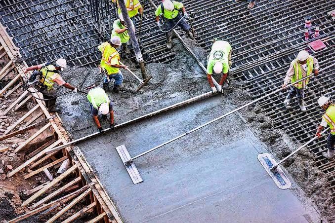 Equipe sarrafeando piso de concreto